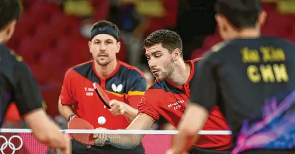  ?? Foto: Swen Pförtner, dpa ?? Timo Boll (links hinten) und Patrick Franziska waren beim 0:3 im Auftaktdop­pel gegen Ma Long und Xu Xin chancenlos.