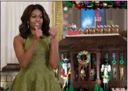  ?? (File Photo/AP/Carolyn Kaster) ?? First lady Michelle Obama speaks Dec. 2, 2015, in the State Dining Room, where children made holiday crafts and treats during a preview of the 2015 White House holiday decor. Behind the first lady is the White House Gingerbrea­d House.