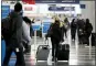  ?? NAM Y. HUH — THE ASSOCIATED PRESS FILE ?? On Nov. 29, a traveler wears a mask as she walks through Terminal 3 at O’Hare Internatio­nal Airport in Chicago.