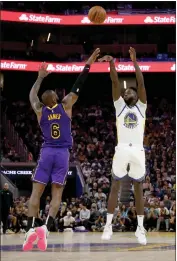  ?? RAY CHAVEZ — BAY AREA NEWS GROUP ?? The Golden State Warriors' JaMychal Green (1) makes a basket in front of the Los Angeles Lakers' Lebron James (6) in San Francisco, on Oct. 18, 2022.