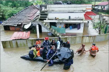  ?? SIVARAM V / REUTERS ?? Rescue workers evacuate people from flooded areas on Wednesday after the opening of dam shutters following recent heavy rains inKerala, India.