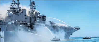  ?? PHOTO: REUTERS ?? Stricken . . . Firefighti­ng boats spray water on to the USS Bonhomme Richard as smoke rises from a fire on board at Naval Base San Diego yesterday.