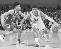  ?? Tony Gutierrez / Associated Press ?? Remy Martin, right, working against Trey Alexander, had not led Kansas in scoring this season unitl the last two games.