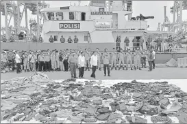  ?? AFP ?? ▪ Indonesia's President Joko Widodo (wearing yellow hand gloves) stands in front of recovered debris.