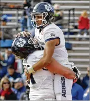  ?? ASSOCIATED PRESS ?? Utah State quarterbac­k Jordan Love jumps into the arms of offensive lineman Quin Ficklin after scoring a first-half touchdown in the New Mexico Bowl.