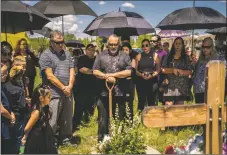  ?? ?? Roy Madrid I, center, is surrounded by family members and friends as they put Max Madrid to rest in the Saint Francis cemetery on Friday (Aug. 5) in Ranchos De Taos.