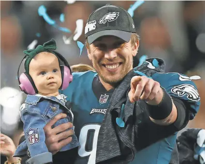 ?? MARK J. REBILAS/USA TODAY SPORTS ?? Quarterbac­k Nick Foles celebrates with daughter Lily after he led the Eagles’ comeback victory against the Patriots for the franchise’s first Super Bowl title.