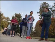  ?? (AP/Jeff Amy) ?? Voters fill out forms as they wait in line to cast ballots in the last hour of early voting earlier this month in the Atlanta suburb of Tucker, Ga.