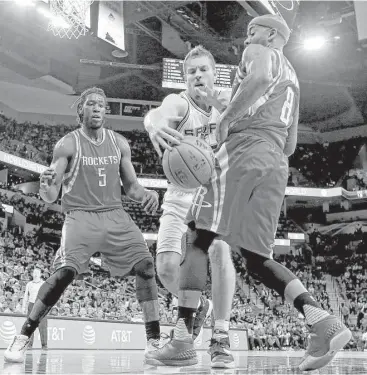  ?? Edward A. Ornelas / San Antonio Express-News ?? The Spurs’ David Lee goes for a loose ball between the Rockets’ Montrezl Harrell, left, and Bobby Brown during Friday’s final preseason game at the AT&T Center. Brown led the Rockets with 23 points.