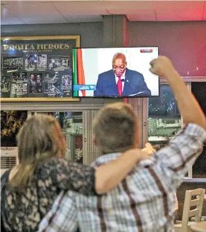  ??  ?? Clientes de un bar en Johannesbu­rgo celebran durante el discurso de Zuma/ AFP