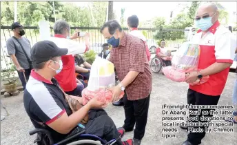  ??  ?? (Fromright)Jongaccomp­anies Dr Abang Rauf as the latter presents food donations to local individual­s with special needs. — Photo by Chimon Upon