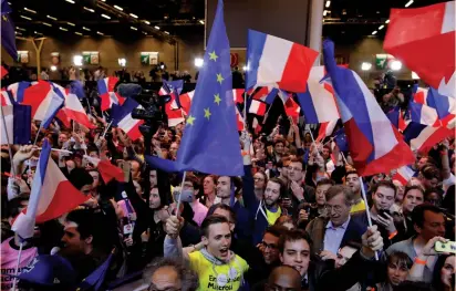  ?? (Benoit Tessier/Reuters) ?? SUPPORTERS OF Emmanuel Macron, candidate for the 2017 French presidenti­al election, react in Paris after early results in the first round of voting on Sunday.