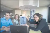  ?? BRITTAINY NEWMAN — THE ASSOCIATED PRESS ?? Anna Salton Eisen holds up a photo of Emil Ringel, father of Barbara Ringel, for a Zoom video call during a gathering for families of Holocaust survivors in East Brunswick, N.J., on Sunday.