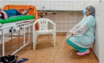  ?? JOAO PAULO GUIMARAES/AGENCE FRANCE-PRESSE ?? AFTER a patient suffering from Covid-19 receives oxygen, a medical worker reacts at a makeshift hospital in a remote community on the coasts of the Moju River in Para state, Brazil.