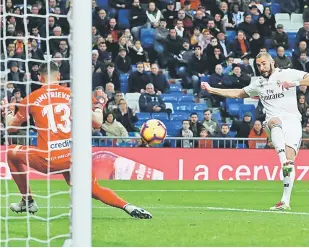  ?? — Gambar Reuters ?? GOL PEMBUKAAN: Benzema (kanan) melepaskan rembatan sebelum menjaringk­an gol pertama Real ketika beraksi pada perlawanan La Liga Sepanyol menentang Rayo Vallecano di Stadium Santiago Bernabeu, Madrid Sabtu lepas.