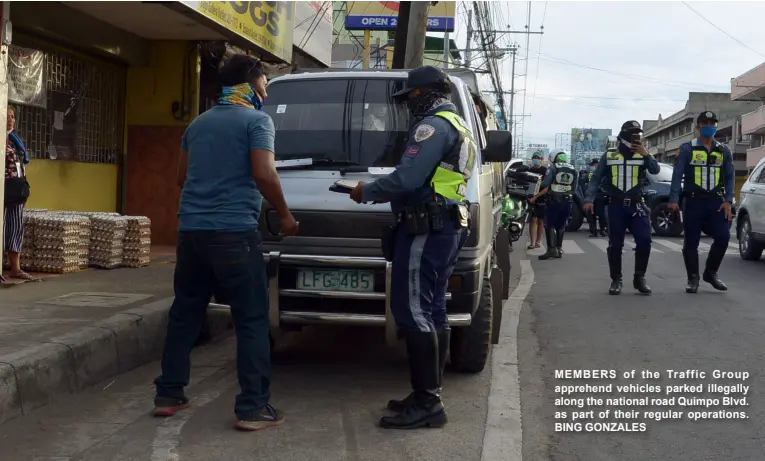  ?? BING GONZALES ?? MEMBERS of the Traffic Group apprehend vehicles parked illegally along the national road Quimpo Blvd. as part of their regular operations.