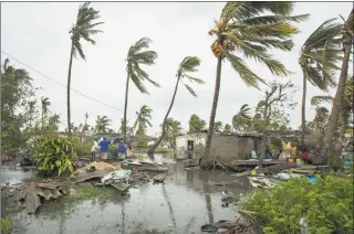  ?? Josh Estey / Associated Press ?? People return to their homes following a cyclone, and heavy rain in the coastal city of Beira, Mozambique, on Sunday.