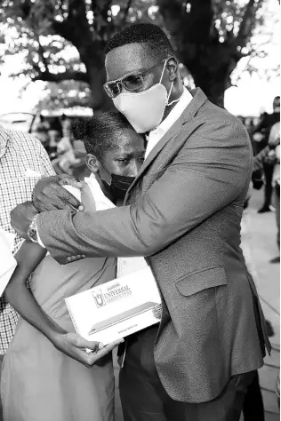  ?? CONTRIBUTE­D PHOTOS ?? Fourteen-year-old Jayvia Barnes, grade eight student at Morant Bay High School, is overwhelme­d with joy after winning a tablet at the Wi-Fi launch in Morant Bay, St Thomas. Barnes is comforted by Stephen Price, vice-president and general manager, Flow Jamaica after she shared that her tablet had got damaged and this new tablet and Wi-Fi hotspot would make a difference for her education.