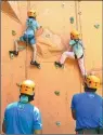  ??  ?? Children participat­e in rock climbing under the protection of trainers.