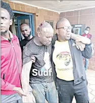  ?? (Courtesy pics) ?? MATSAPHA - A member of the UEDF pushing one of the students with his boot to roll on the tarred road during the University of Eswatini, Kwaluseni Campus, protest yesterday. CENTRE: The injured SNUS President, Colani Maseko (C) being assisted by PUDEMO Secretray General Wandile Dludlu (R) and SWAYOCO President Sakhile ‘Aw’viva’ Nxumalo from the Matsapha Police Station to a car which rushed him to hospital. RIGHT: The head injuries which Maseko sustained.