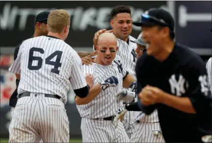  ?? JULIE JACOBSON — THE ASSOCIATED PRESS ?? Brett Gardner, center, is mobbed by teammates after driving in Jacoby Ellsbury for the wining run against the Rays on Saturday.