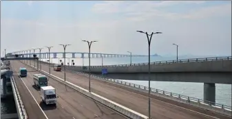  ?? SERVICES DEPARTMENT HKSAR INFORMATIO­N ?? Cross-boundary buses and trucks are seen on the Hong Kong-Zhuhai-Macao Bridge.