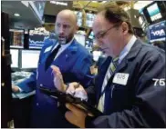  ?? RICHARD DREW — THE ASSOCIATED PRESS ?? Specialist Meric Greenbaum, left, and trader James Conti work on the floor of the New York Stock Exchange on Wednesday.