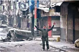  ??  ?? A Syrian man gestures in the former rebel-held Salaheddin district in the northern Syrian city of Aleppo