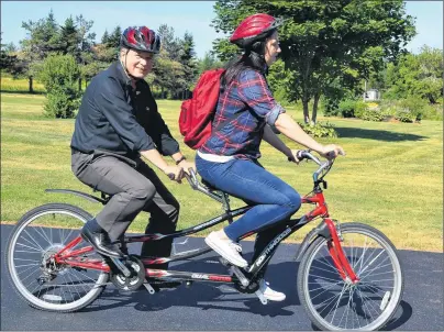  ?? ERIC MCCARTHY/JOURNAL PIONEER ?? Dr. Herb Dickieson and his daughter, Alexandra, depart from an interview Tuesday on a tandem bicycle. His current leave, he said, has afforded him more time to focus on his personal health. He’s retiring from the O’Leary Health Centre in September.