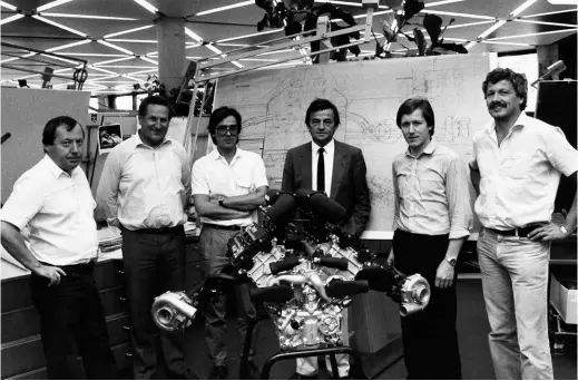  ??  ?? Above: Hans Mezger (in suit) behind the Porsche TAG engine. From left to right: Hans Bischof, Bruno Anklam, Joachim Kelm, Hans Mezger, Dieter Nowack and Peter Schmid