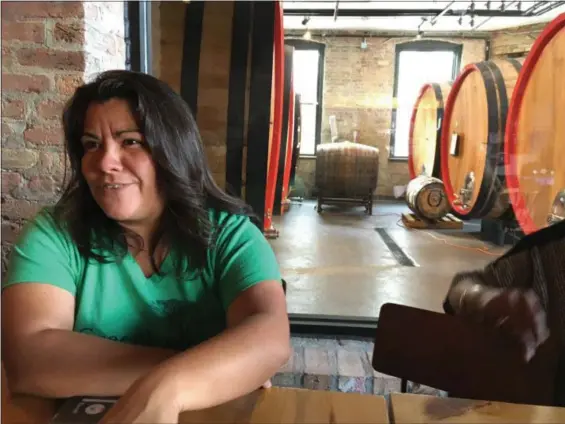  ?? JANET PODOLAK — THE NEWS-HERALD ?? Liz Garibay tells those in her History on Tap walking tour of Chicago’s bars about a brewery where they’ve landed.