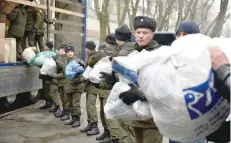  ?? — AFP ?? Servicemen of the National Guard of Ukraine and communal workers load a humanitari­an aid for Avdiivka inhabitant­s on a lorry in central Kiev.