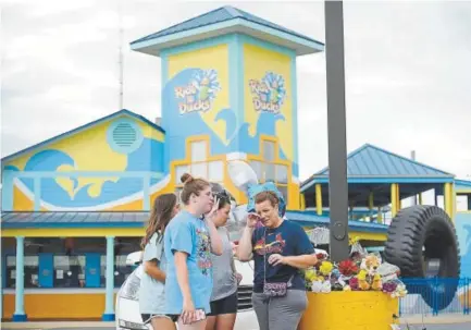  ??  ?? Mourners pause for a moment of prayer at Ride the Ducks Tours on Friday in Branson, Mo.