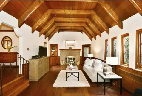  ?? Melissa Carter photos ?? The living room has a coffered wood ceiling, hardwood floors, leaded-glass windows and a stone fireplace.