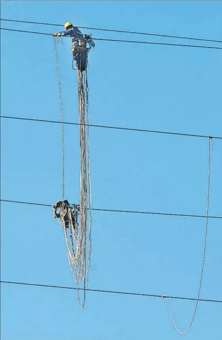  ?? MANÉ ESPINOSA / ARCHIVO ?? Unos operarios retirando cables eléctricos en la sierra de Collserola