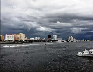  ?? GREG LOVETT / THE PALM BEACH POST ?? Heavy clouds move over the city of West Palm Beach during late afternoon as seen from the middle bridge to Palm Beach on Thursday.