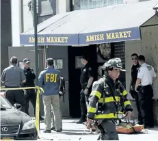  ?? MARK LENNIHAN/THE ASSOCIATED PRESS ?? Emergency personnel are seen after a carbon monoxide leak in New York’s Tribeca neighbourh­ood. The leak was caused by a broken pipe in a grocery store basement, and not by a box of salad bowls as originally feared.