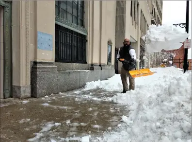  ?? Photo by Russ Olivo ?? Dennis Harmon gives it the ol’ heave-ho as he clears a sidewalk on Main Street Monday across the street from Action Based Enterprise­s, where he works as a behavioral specialist.