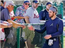  ?? CURTIS COMPTON / CCOMPTON@AJC.COM ?? Shortstop Dansby Swanson signs autographs after taking batting practice this spring. Swanson failed to live up to hype last season. Now the hype is aimed elsewhere.