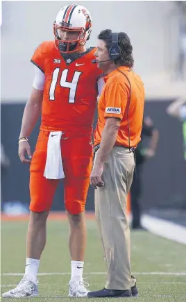  ?? [PHOTO BY SARAH PHIPPS, THE OKLAHOMAN] ?? Oklahoma State coach Mike Gundy talks with quarterbac­k Taylor Cornelius (14) during the Cowboys’ season opener against Missouri State on Aug. 30.