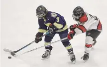  ?? Dave Stewart/Hearst Connecticu­t Media ?? Newington’s Jack Petronio (3) and Masuk’s Austin Braiewa (23) battle for the puck during the CIAC Div. 3 boys ice hockey final at Quinnipiac on Monday.