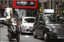  ?? KIRSTY WIGGLESWOR­TH / ASSOCIATED PRESS ?? Traffic moves through central London on Wednesday. British government officials say they hope that by 2050, “almost every car and van on the road” will be a zeroemissi­ons vehicle.