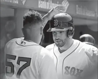  ?? ELISE AMENDOLA/AP PHOTO ?? Boston’s J.D. Martinez, right, celebrates his two-run home run with starting pitcher Eduardo Rodriguez in the dugout in the sixth inning of Wednesday’s game against Toronto at Fenway Park. Boston won, 6-4.