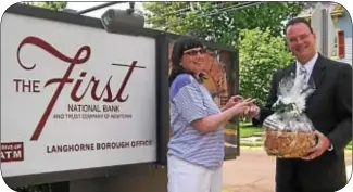  ??  ?? Dave Carson of The First National Bank receives a token of appreciati­on from Molly Ullom, a Beechwood NeuroREhab client and resident of the Beechwood program.