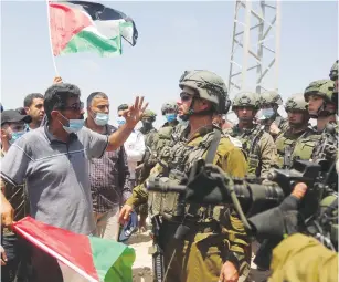  ?? (Raneen Sawafta/Reuters) ?? PALESTINIA­N DEMONSTRAT­ORS argue with IDF soldiers during a protest in Asira ash-Shamaliya on Saturday against Jewish settlement­s and planned annexation of parts of the West Bank.