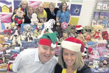  ??  ?? Thank you Travel consultant James Rix and Princes Square store manager Lorraine Stairmand, front, celebrate their toy appeal success with staff