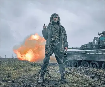  ?? ?? BATTLE: A Ukrainian soldier gestures as a captured Russian T-80 tank fires at the Russian position in the Donetsk region of Ukraine yesterday.