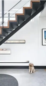  ??  ?? HALLWAY Slotted windows reflect an ever-changing canvas of light and shade as the sun moves. Staircase designed by architect Peter Wells. Black round rug, £95, Vanil