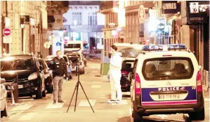  ??  ?? SEORANG pegawai forensik (kanan) dan seorang anggota polis menjalanka­n siasatan di sekeliling tempat kejadian di jalan Saint Augustin di Paris, kelmarin. — Gambar AFP