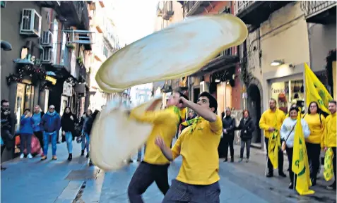  ??  ?? The Pizzaioli Acrobats Coldiretti team performs pizza-twirling in the streets of Naples to celebrate. The industry employs 100,000 people and is worth £8.8 billion to the economy
